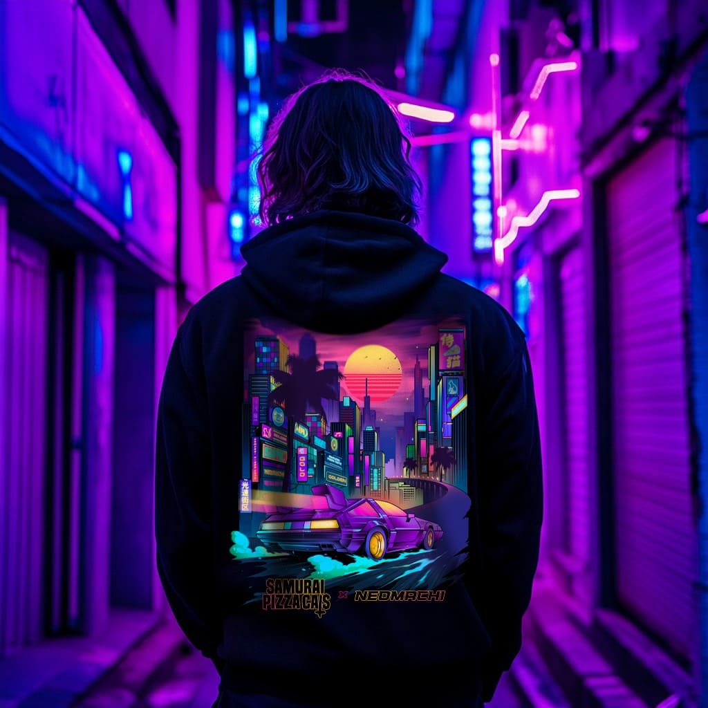 Person wearing a hoodie with a vibrant cityscape design in a neon-lit alley.