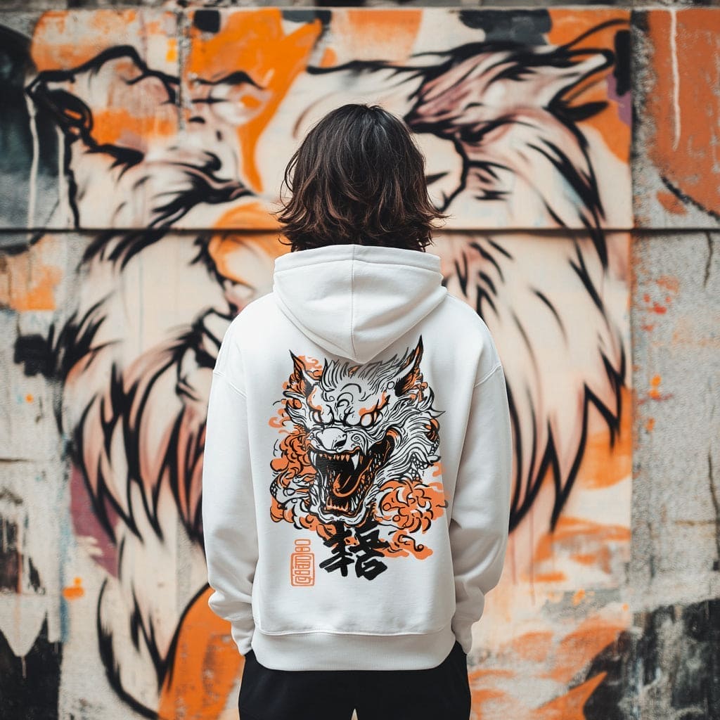 Person wearing a hoodie with a dragon design in front of a graffiti wall.